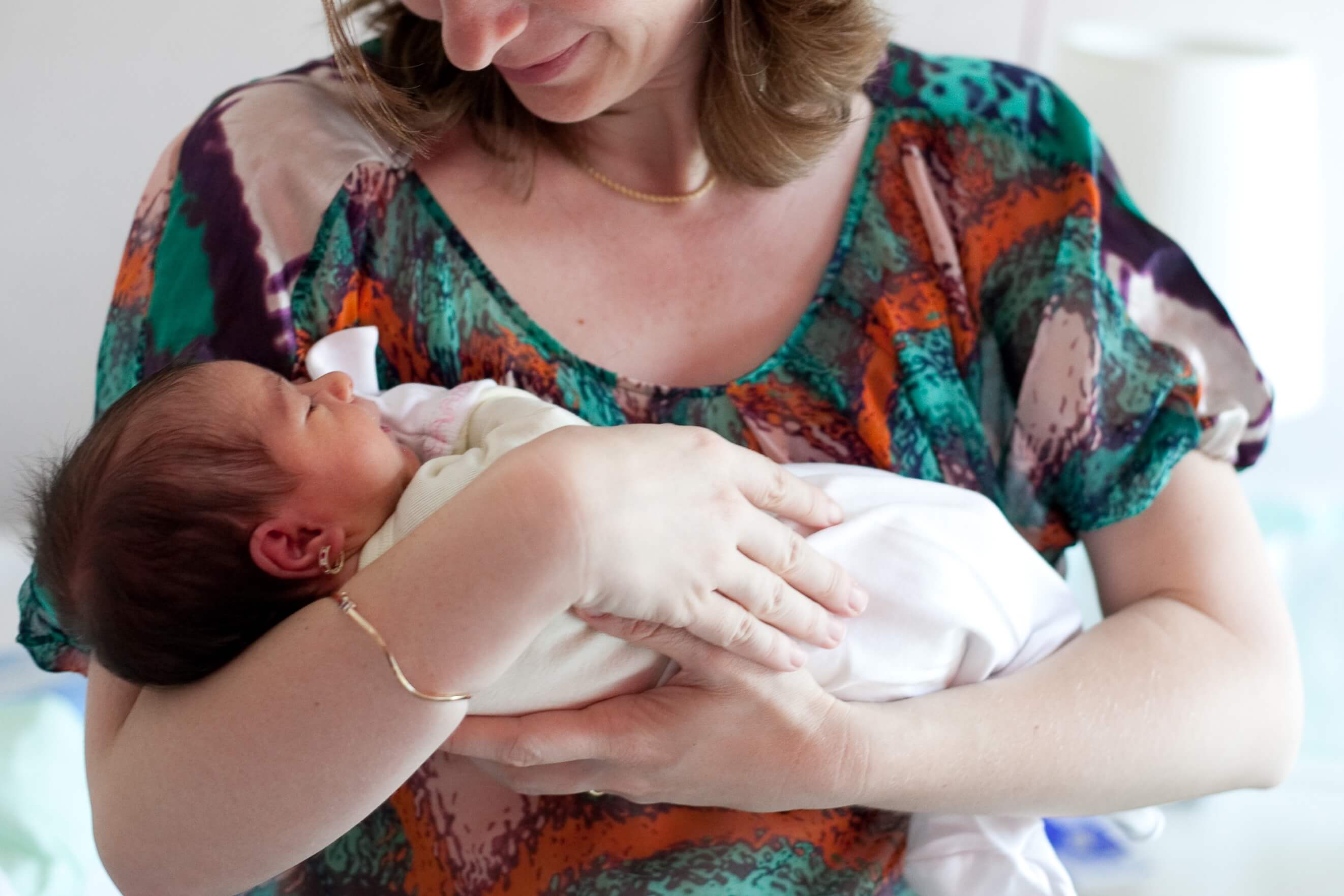 anne yenidoğan bebeğini kucağında tutuyor